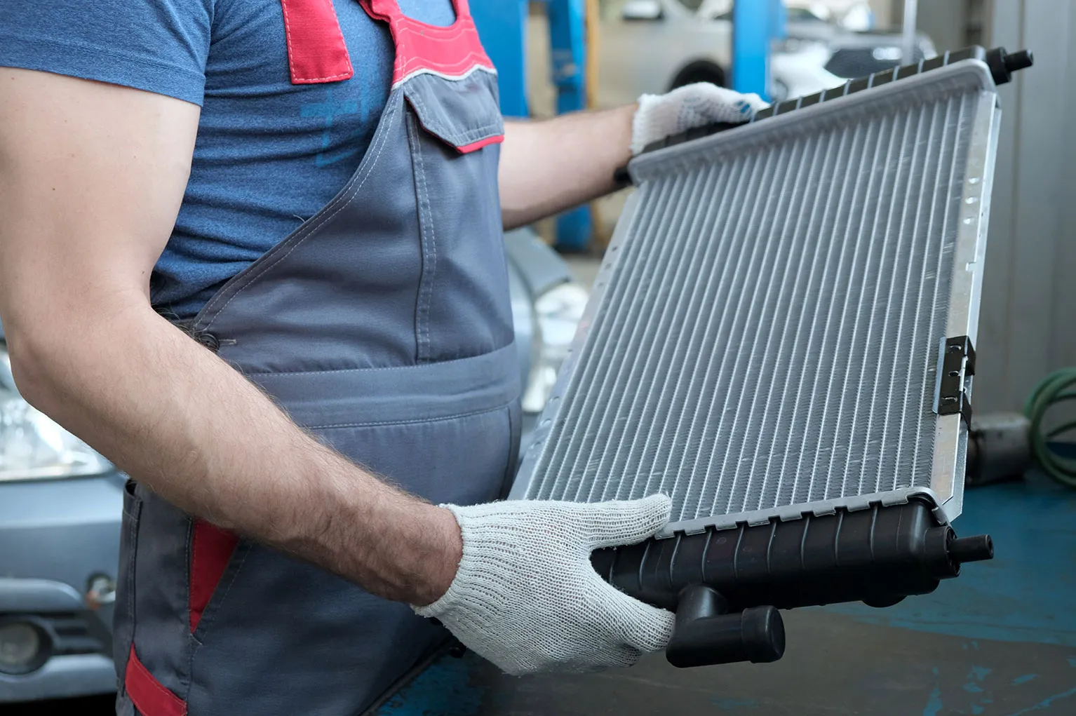 A man holding a radiator in his hands.